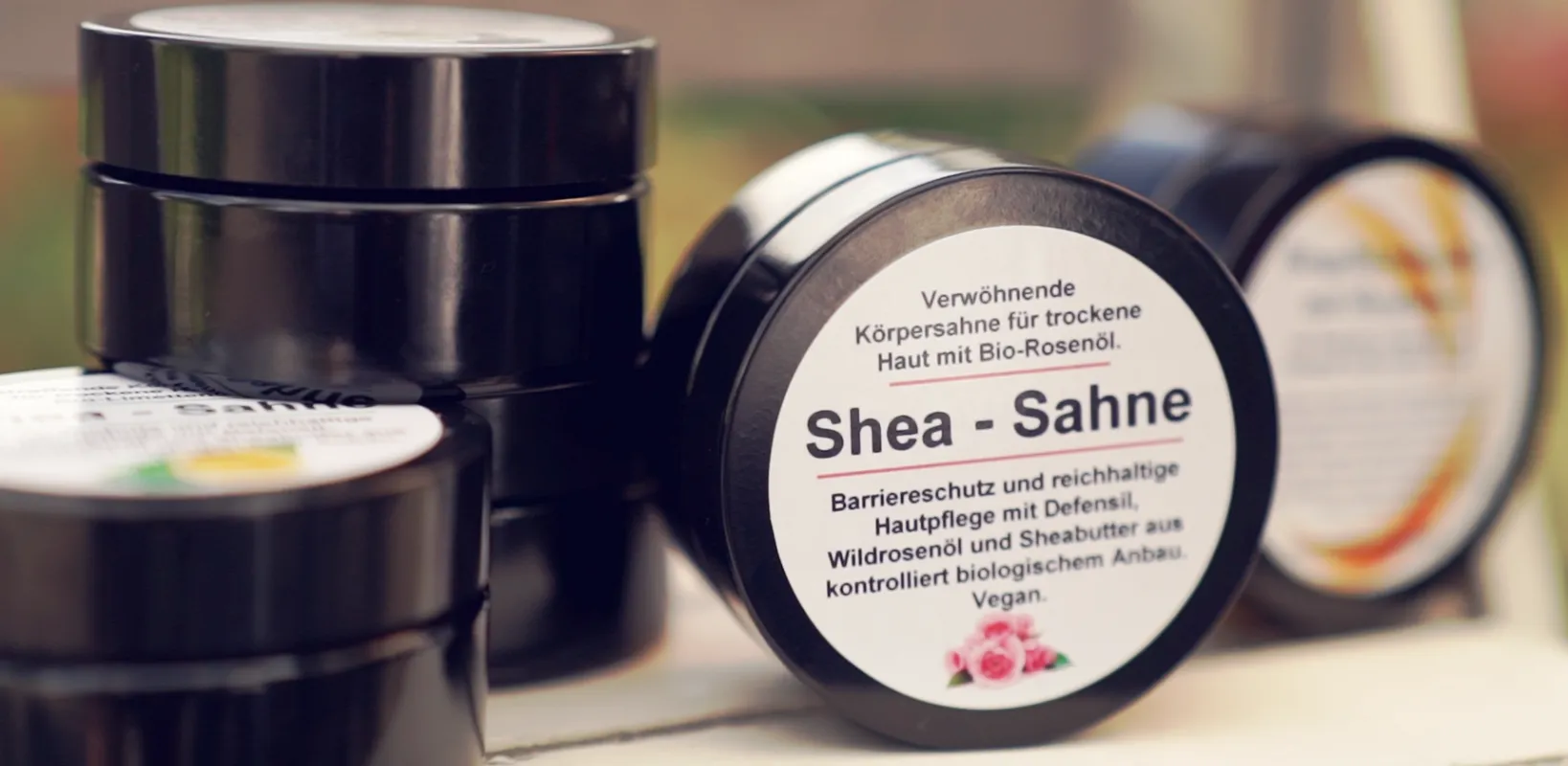 Eine Auswahl an festen Shampoos von Thoma Naturpflege in verschiedenen Sorten wie Lavendel, Karité und Zitrone. Im Bild sind außerdem handgemachte Seifen und eine Geschenkbox mit der Aufschrift 